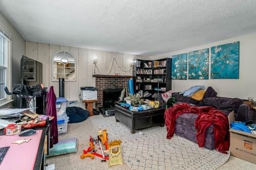 playroom with a fireplace, light carpet, and a textured ceiling