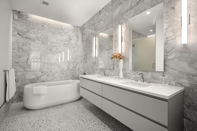 bathroom featuring tile walls, vanity, and a washtub