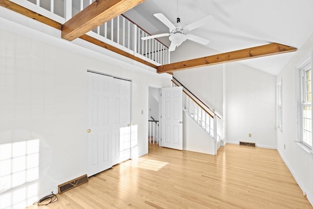 foyer featuring light wood-type flooring, ceiling fan, high vaulted ceiling, and beam ceiling