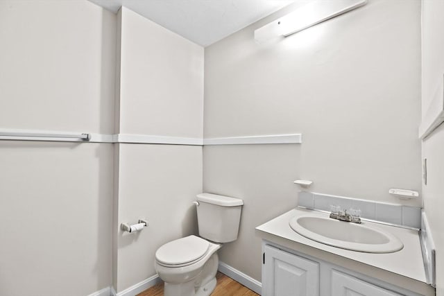 bathroom featuring hardwood / wood-style floors, toilet, and vanity