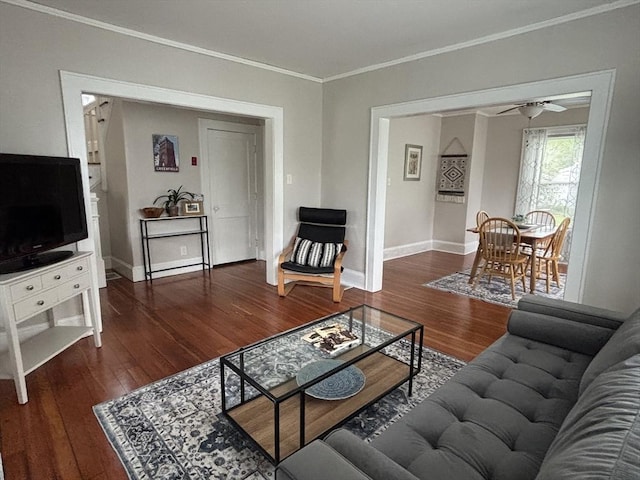 living room featuring baseboards, ornamental molding, a ceiling fan, and wood finished floors