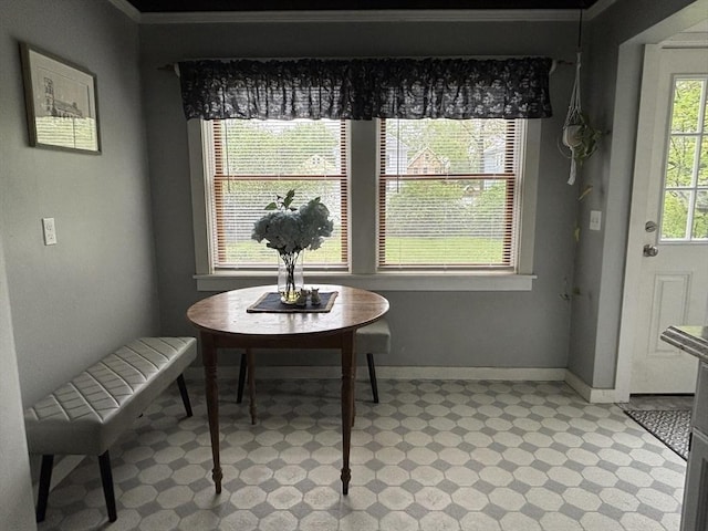 dining space with baseboards, light floors, and crown molding