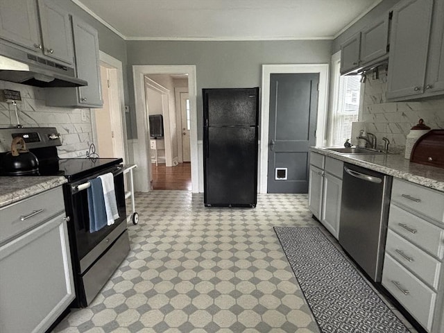 kitchen featuring a sink, tasteful backsplash, light floors, under cabinet range hood, and appliances with stainless steel finishes