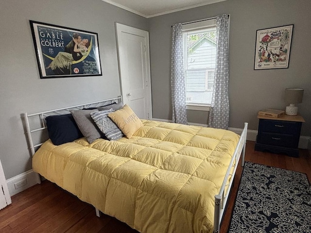 bedroom featuring dark wood-style flooring, baseboards, and ornamental molding