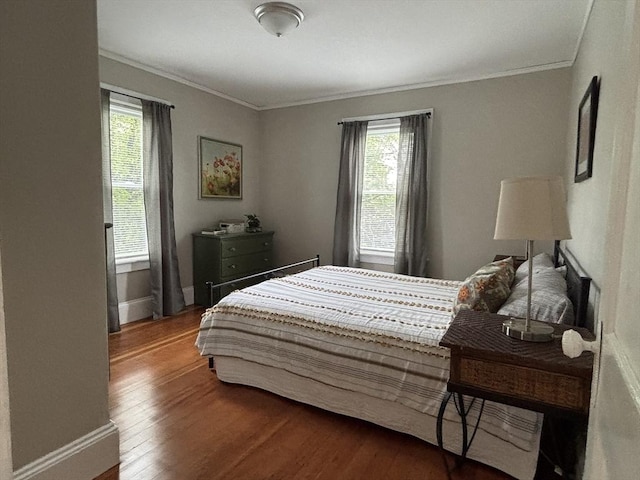 bedroom featuring ornamental molding, dark wood-style floors, and multiple windows
