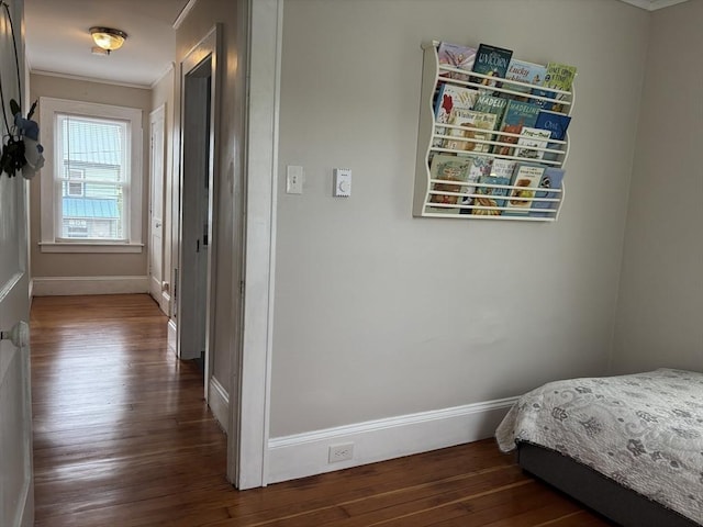 bedroom featuring baseboards, dark wood finished floors, and crown molding