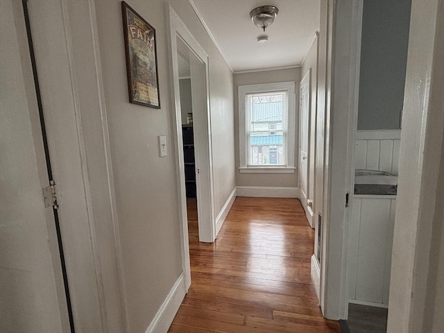 hall featuring ornamental molding, baseboards, and dark wood-style floors