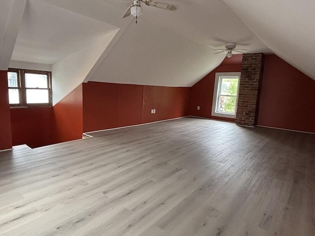 additional living space with vaulted ceiling, wood finished floors, and a ceiling fan