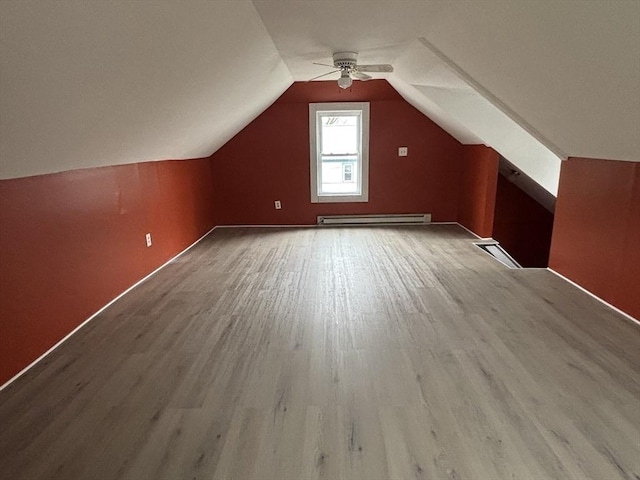 bonus room with vaulted ceiling, wood finished floors, a ceiling fan, and a baseboard heating unit