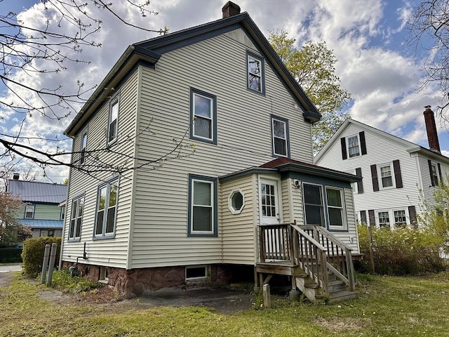 back of house with a chimney