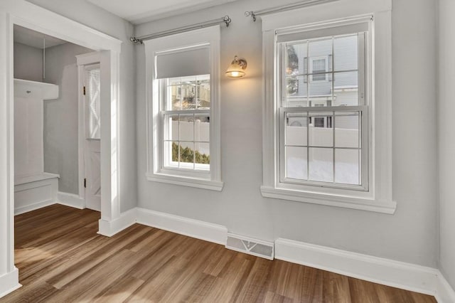 interior space with baseboards, visible vents, and wood finished floors