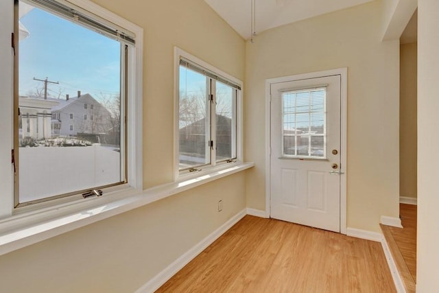 doorway to outside featuring plenty of natural light, light wood-style flooring, and baseboards