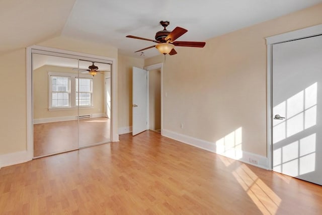 empty room with light wood-type flooring, ceiling fan, baseboards, and vaulted ceiling