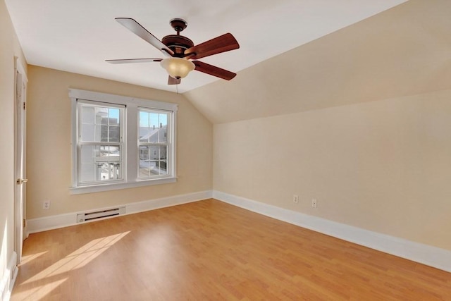 bonus room with a baseboard radiator, baseboards, vaulted ceiling, and light wood finished floors