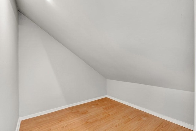 bonus room with baseboards and wood finished floors