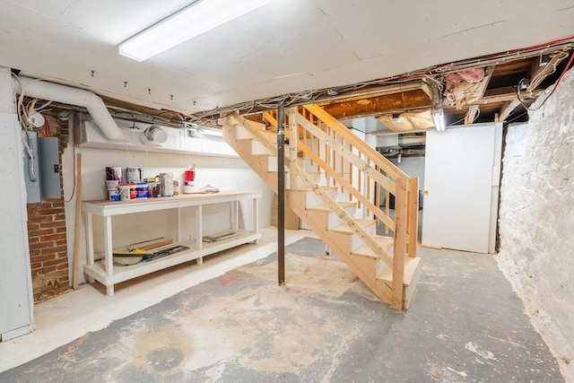 unfinished basement with water heater and stairway