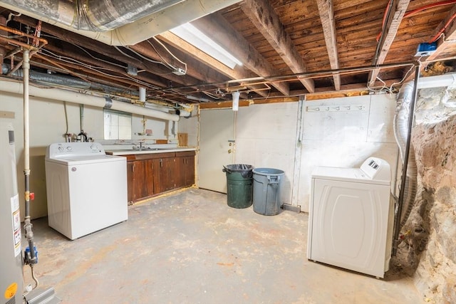 unfinished below grade area featuring washing machine and dryer, water heater, and a sink