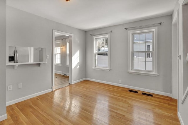 interior space with visible vents, light wood-style flooring, and baseboards