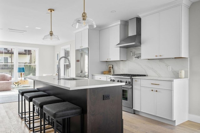 220 Bowen St Unit 2, Boston, MA 02127 - kitchen with wall chimney range hood, high quality appliances, a sink, light wood-type flooring, and light countertops
