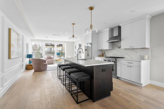 220 Bowen St Unit 2, Boston, MA 02127 - kitchen with high quality appliances, wall chimney exhaust hood, a sink, light countertops, and a kitchen breakfast bar