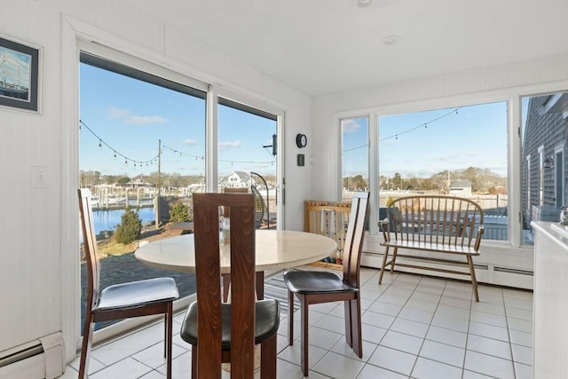 dining room featuring a baseboard heating unit, light tile patterned flooring, a water view, and baseboard heating