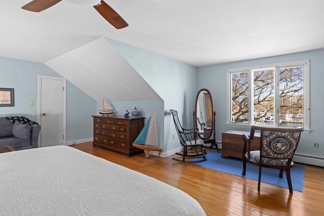 bedroom with a ceiling fan, lofted ceiling, wood finished floors, and baseboards