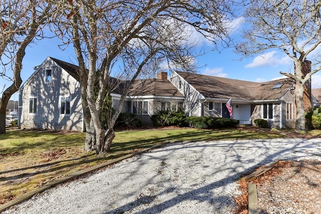 view of front of property with a chimney and a front lawn