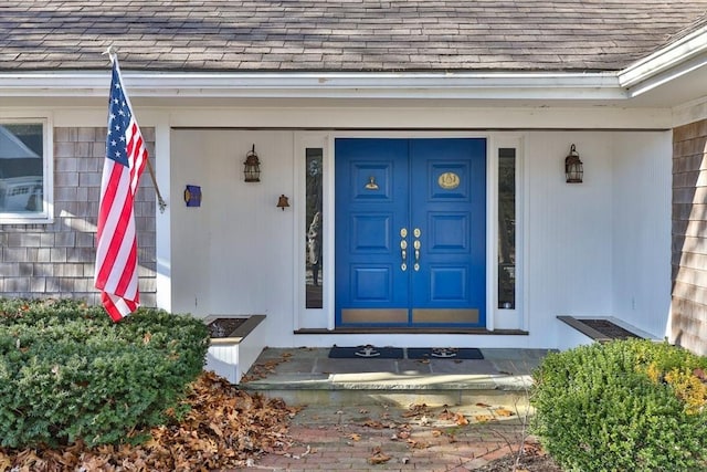 doorway to property with a shingled roof