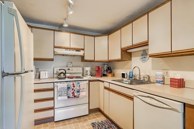 kitchen featuring sink, track lighting, and white appliances