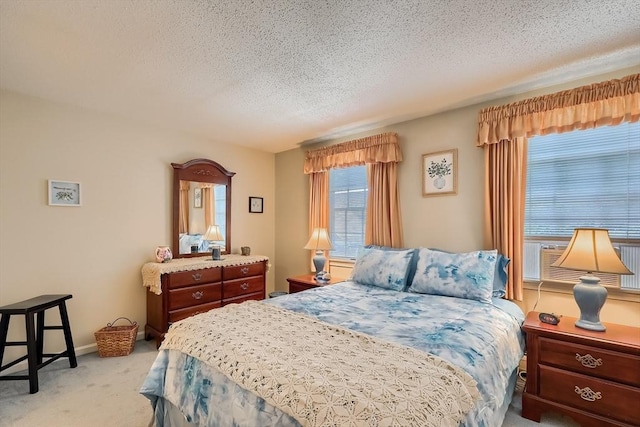 bedroom with light colored carpet and a textured ceiling