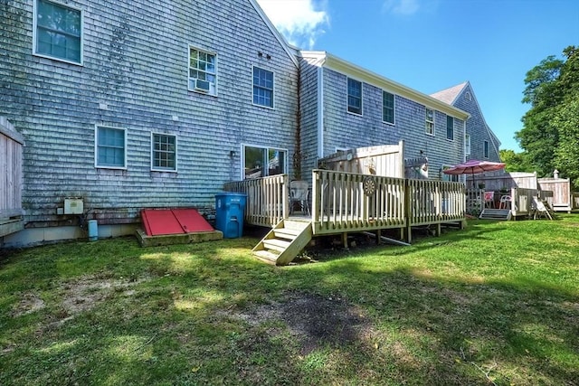 back of property with a lawn and a deck