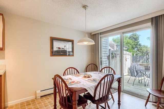 dining area featuring a textured ceiling and a baseboard heating unit