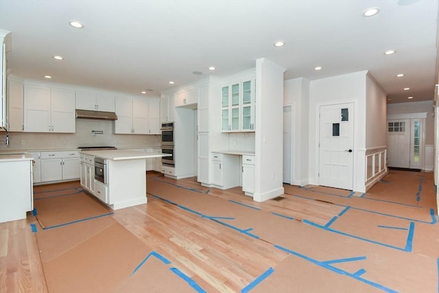 kitchen with light wood-type flooring, under cabinet range hood, appliances with stainless steel finishes, and recessed lighting