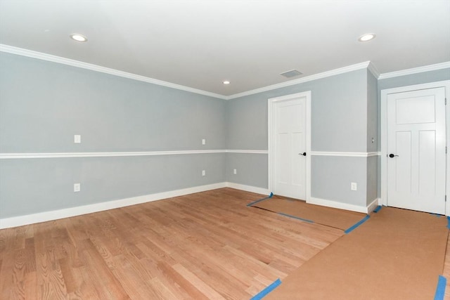 spare room with visible vents, baseboards, wood finished floors, crown molding, and recessed lighting