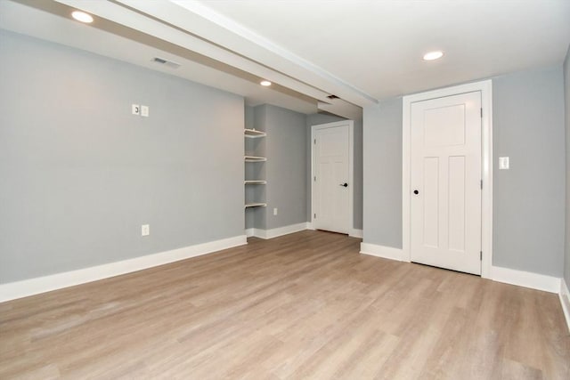 empty room with light wood-style floors, recessed lighting, visible vents, and baseboards