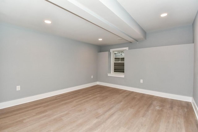 spare room featuring recessed lighting, beam ceiling, baseboards, and wood finished floors