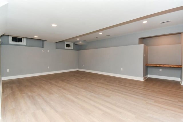 finished basement with recessed lighting, baseboards, and wood finished floors