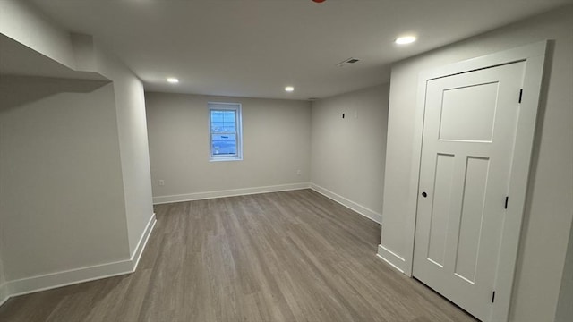 below grade area featuring visible vents, baseboards, wood finished floors, and recessed lighting