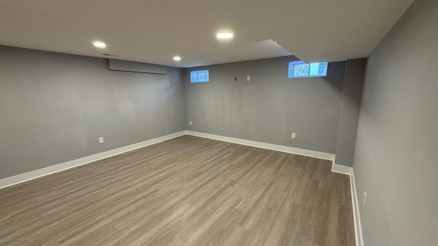 basement with dark wood-style floors, visible vents, and baseboards