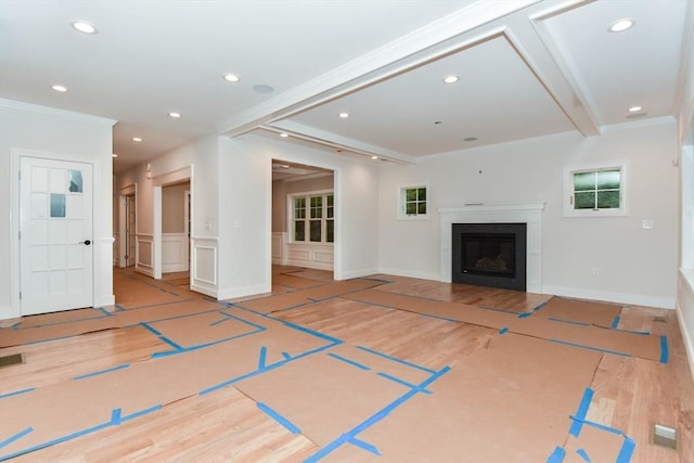 unfurnished living room with a wainscoted wall, ornamental molding, wood finished floors, and recessed lighting