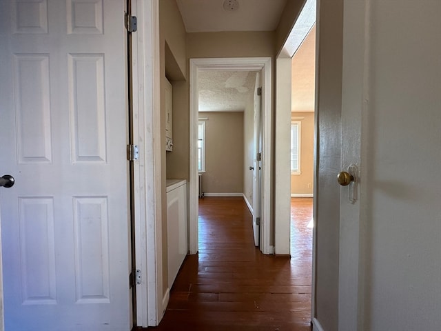 hallway featuring dark hardwood / wood-style floors and a textured ceiling