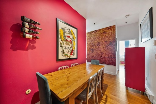 dining area with baseboards and wood finished floors