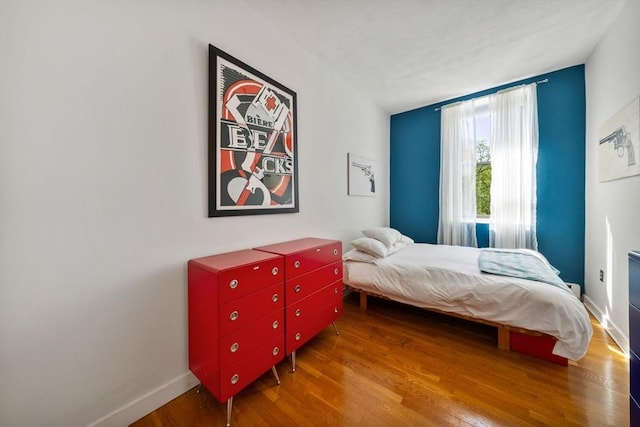 bedroom with baseboards and wood finished floors