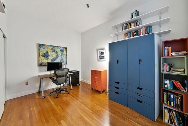 office area with light wood-style floors and baseboards