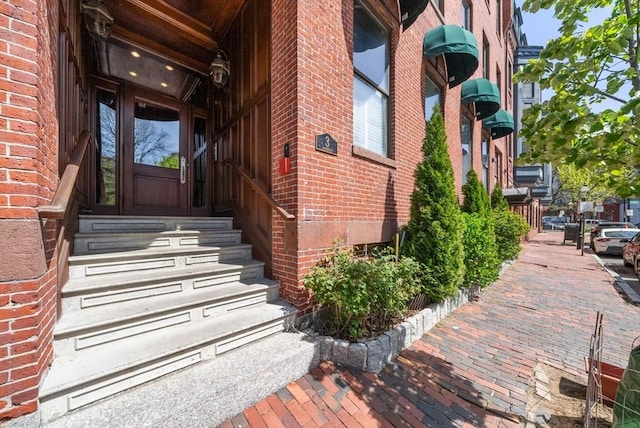 view of exterior entry with brick siding