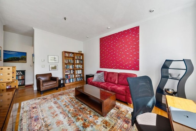 living area with ornamental molding and wood finished floors