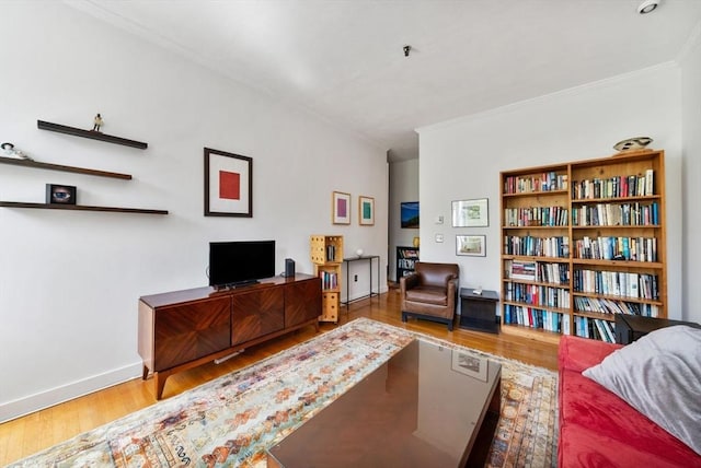 living area with crown molding, baseboards, and wood finished floors