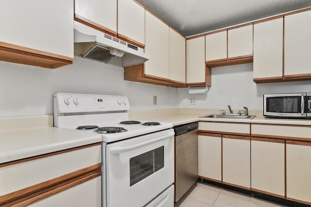 35 Prospect St Unit 313, Woburn, MA 01801 - kitchen with appliances with stainless steel finishes, a sink, under cabinet range hood, light countertops, and a textured ceiling