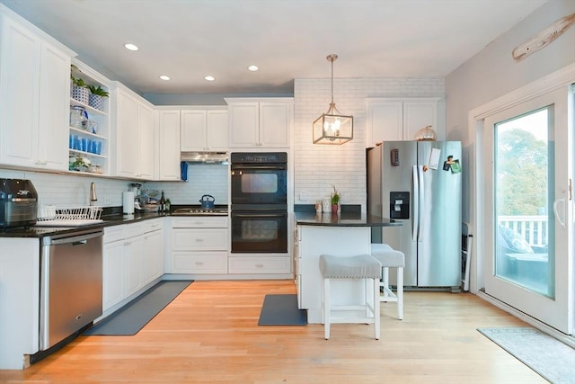 kitchen featuring decorative light fixtures, tasteful backsplash, a breakfast bar, appliances with stainless steel finishes, and white cabinets