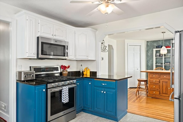 50 Walnut St, Northampton, MA 01060 - kitchen with stainless steel appliances, blue cabinets, white cabinets, dark countertops, and ceiling fan